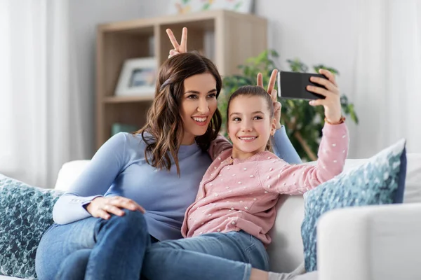 Família feliz tirando selfie por smartphone em casa — Fotografia de Stock