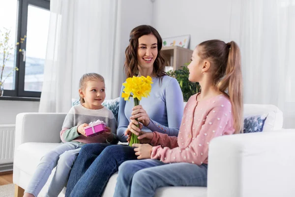 Hijas dando flores y regalo a la madre feliz —  Fotos de Stock