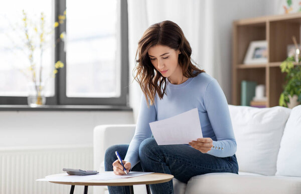 Woman with papers and calculator at home Royalty Free Stock Images