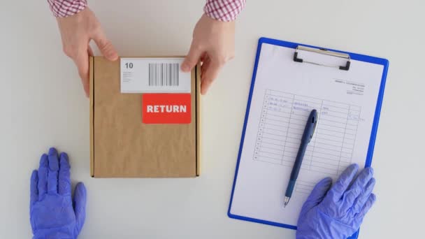 Kund händer returnera paketlåda till postarbetare — Stockvideo