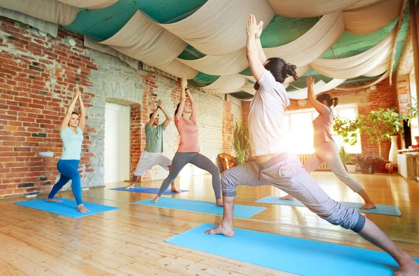 Grupo de personas haciendo yoga guerrero posan en estudio —  Fotos de Stock