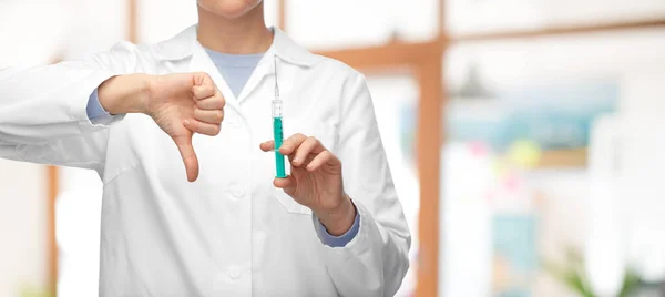 Close up of doctor with syringe shows thumbs down — Stock Photo, Image