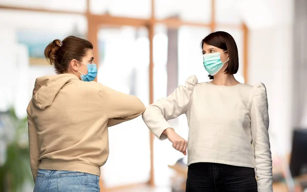 Frauen in Masken machen Ellbogenschlag-Grußgeste — Stockfoto