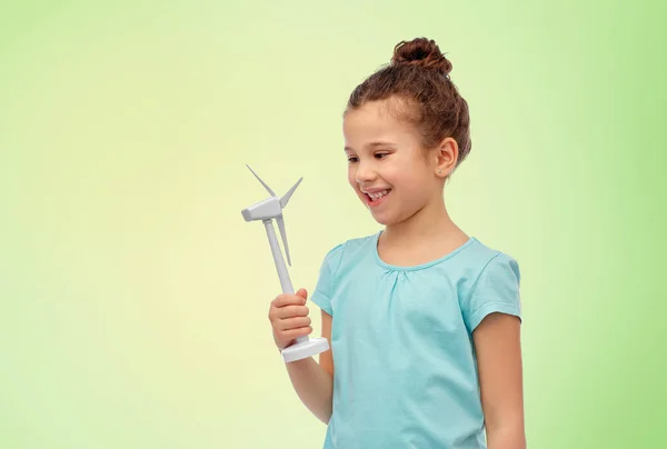 Menina sorridente com turbina eólica de brinquedo — Fotografia de Stock