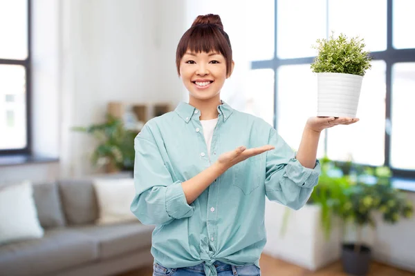 Gelukkig glimlachen aziatische vrouw holding bloem in pot — Stockfoto