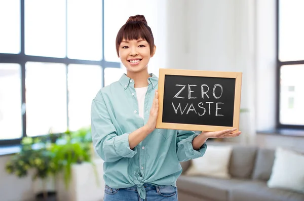Азиатская женщина держит доску с нулевыми словами отходов — стоковое фото