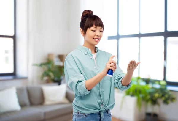 Mutlu gülümseyen Asyalı kadın el dezenfektanı kullanıyor — Stok fotoğraf