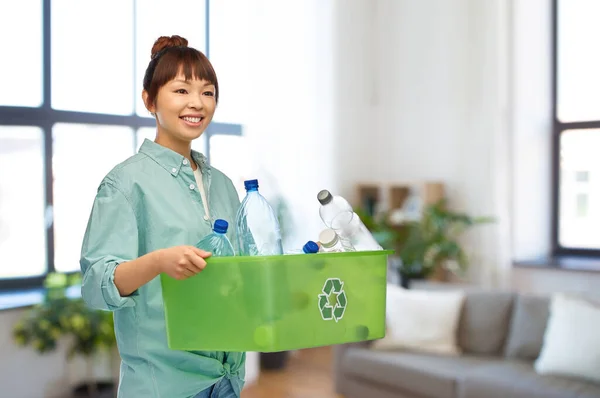 Sorridente giovane donna asiatica cernita rifiuti di plastica — Foto Stock