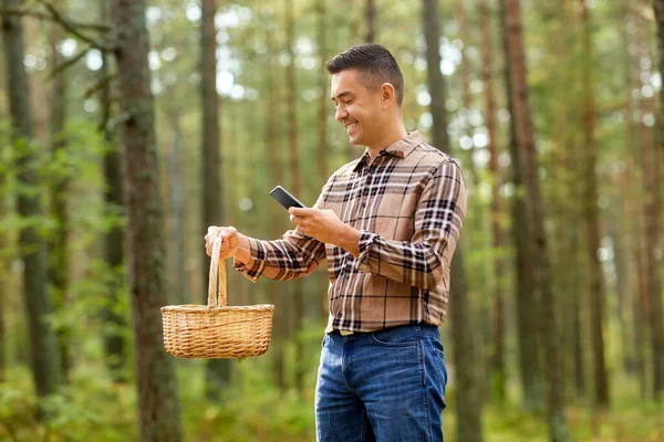 Man met smartphone om paddenstoel te identificeren — Stockfoto