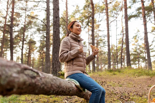 Mulher com cogumelos bebe chá e come na floresta — Fotografia de Stock