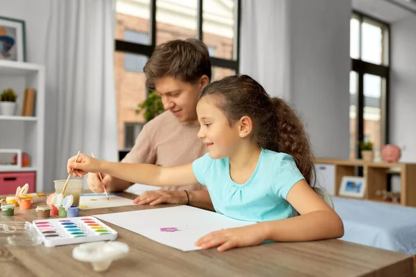 Счастливый отец с маленькой дочкой рисует дома — стоковое фото