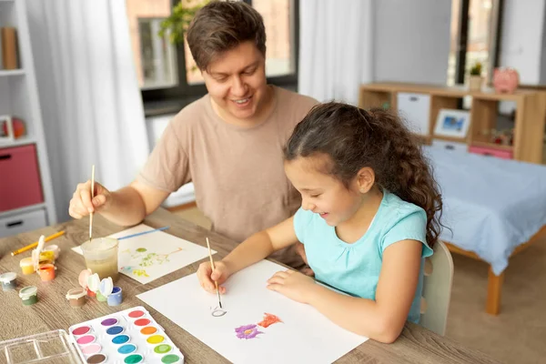 Pai feliz com pequena filha desenho em casa — Fotografia de Stock