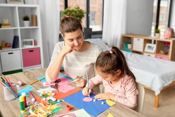 Dotter med mamma gör applikation hemma — Stockfoto