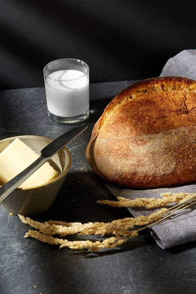 Zbliżenie chleba, masła, noża i szklanki mleka — Zdjęcie stockowe