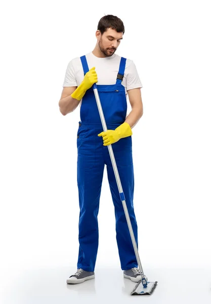 Male cleaner in overal cleaning floor with mop — Stock Photo, Image