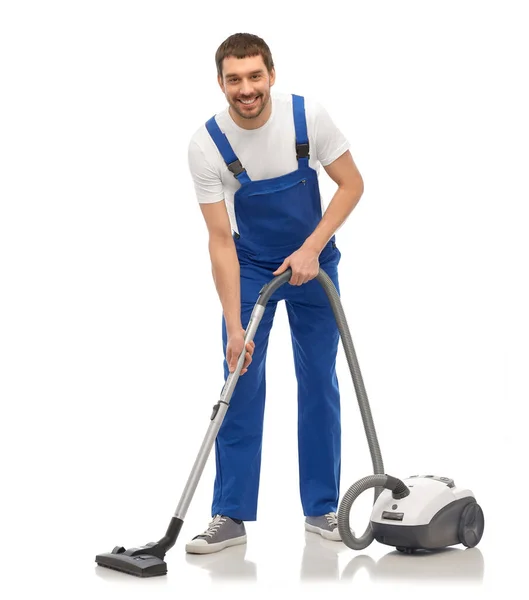 Male worker cleaning floor with vacuum cleaner — Stock Photo, Image