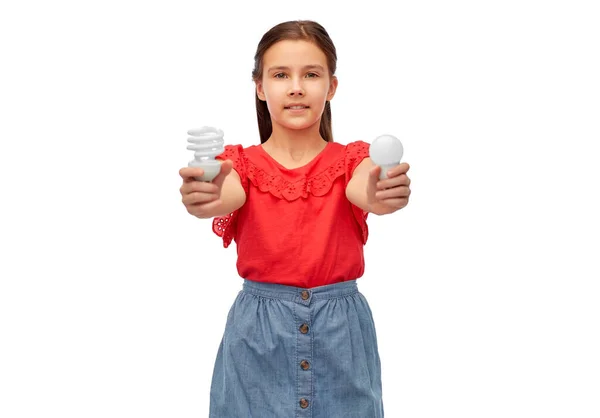 Smiling girl comparing different light bulbs — Stock Photo, Image