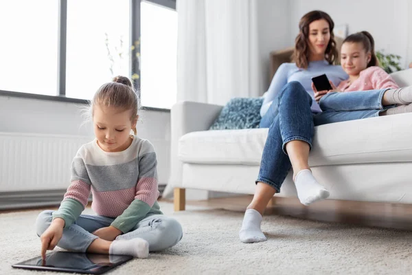 Felice ragazza con tablet pc e famiglia a casa — Foto Stock