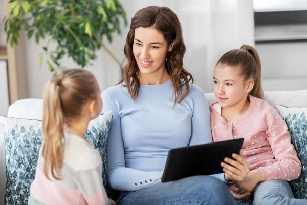 Feliz madre e hijas con la tableta PC en casa — Foto de Stock