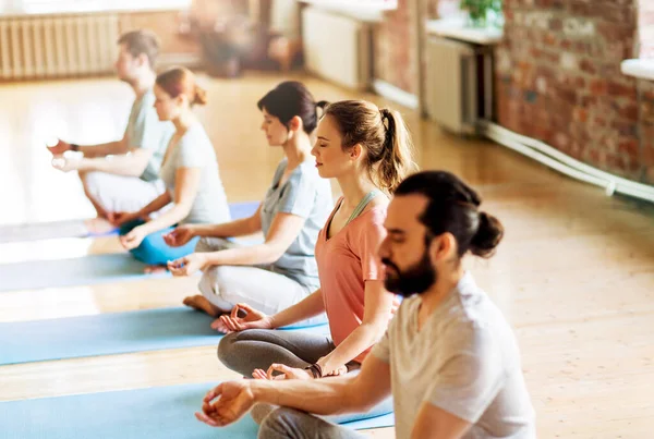 Groep mensen die yoga oefeningen doen in de studio — Stockfoto