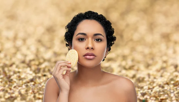 Jovem mulher limpeza rosto com esponja esfoliante — Fotografia de Stock