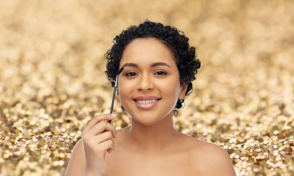Femme afro-américaine souriante avec brosse de mascara — Photo