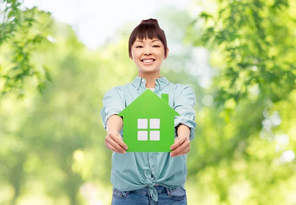 Lächelnde asiatische Frau mit grünem Haus — Stockfoto