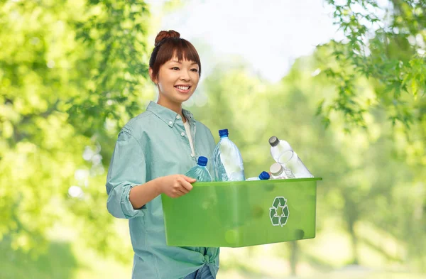 Sonriente joven asiático mujer clasificación plástico residuos — Foto de Stock