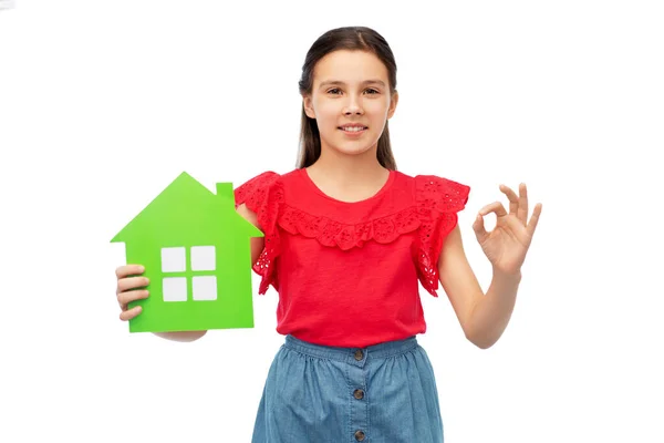 Χαρούμενο κοριτσάκι με πράσινο εικονίδιο σπιτιού που δείχνει εντάξει — Φωτογραφία Αρχείου