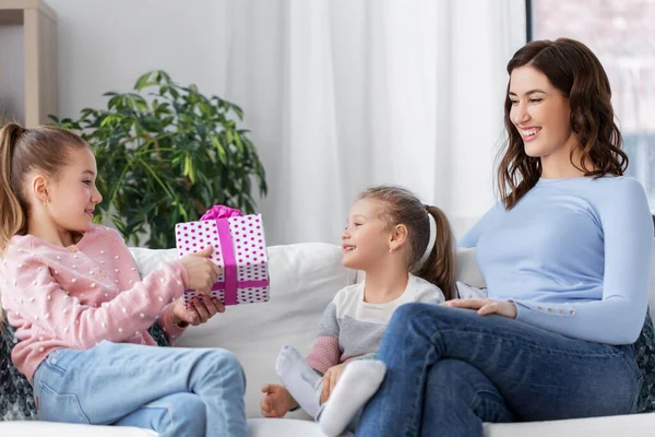 Mädchen beschenkt jüngere Schwester zu Hause — Stockfoto