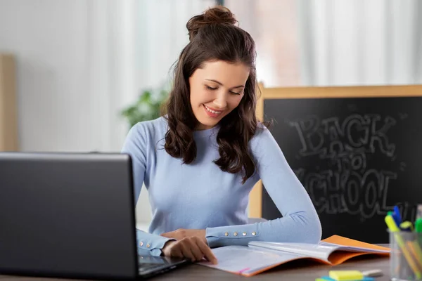 Teacher with laptop and notebook working from home — Stock Photo, Image