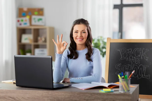 Teacher with laptop and notebook working from home — Stock Photo, Image