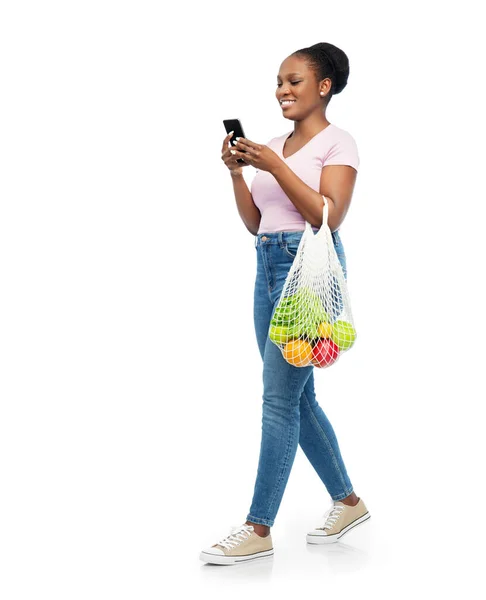 Mujer con smartphone y comida en bolsa de cuerda — Foto de Stock