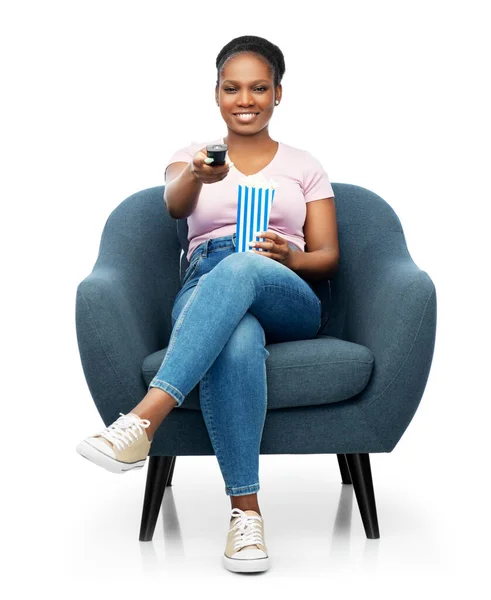 Afrikaanse vrouw die popcorn eet zittend in een fauteuil — Stockfoto