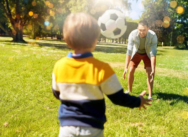 Padre con hijo pequeño jugando al fútbol en el parque — Foto de Stock
