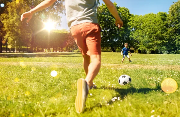 Padre con hijo pequeño jugando al fútbol en el parque — Foto de Stock