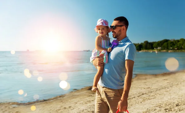 Pai feliz com a pequena filha na praia — Fotografia de Stock