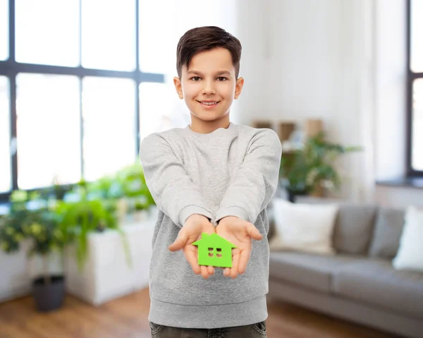 Smiling boy holding green house icon — Stock Photo, Image