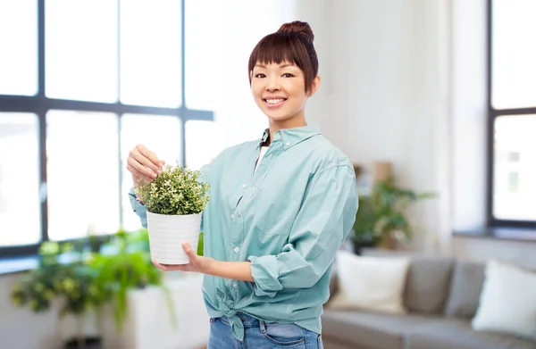 Feliz sonriente asiático mujer celebración flor en pot —  Fotos de Stock