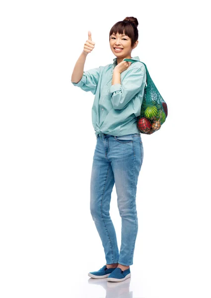 Женщина с едой в веревочном мешке показывает большие пальцы вверх — стоковое фото