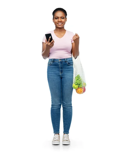 Mulher com smartphone e comida em saco de cordas — Fotografia de Stock