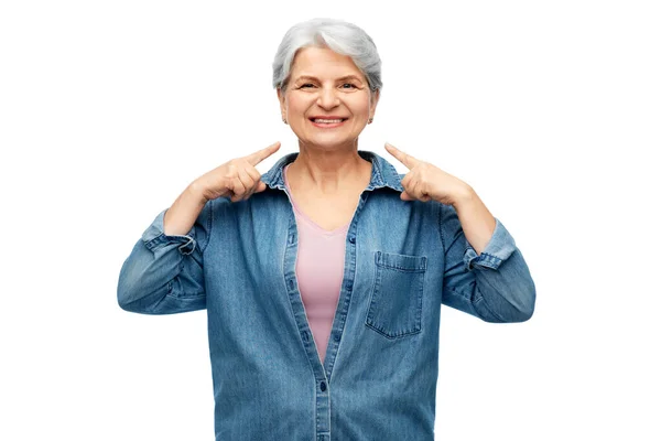 Leende äldre kvinna visar sitt ansikte — Stockfoto