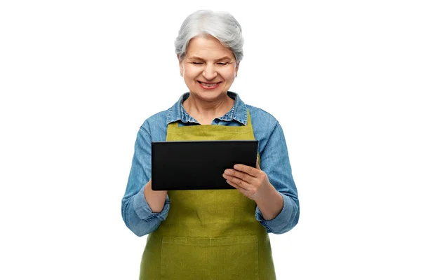 Mujer mayor feliz en delantal de jardín con la tableta de la PC — Foto de Stock