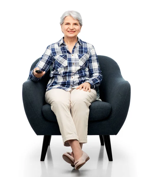 Wanita senior yang bahagia menonton tv duduk di kursi — Stok Foto