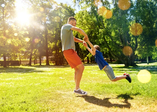 Boldog apa fiával játszik a nyári parkban — Stock Fotó