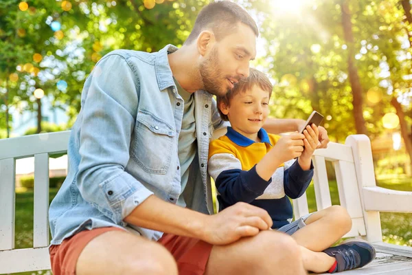 Vater und Sohn mit Smartphone im Park — Stockfoto