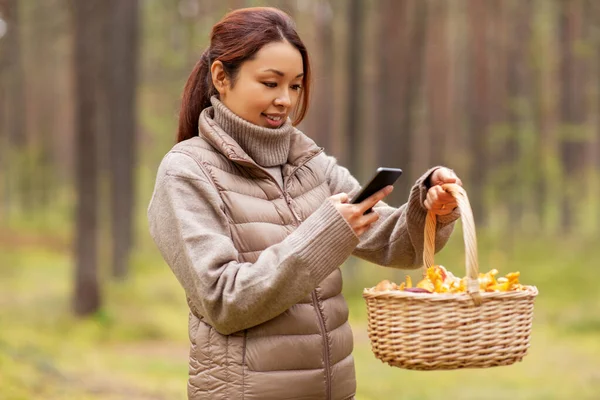 Aziatische vrouw met behulp van smartphone om paddestoel te identificeren — Stockfoto