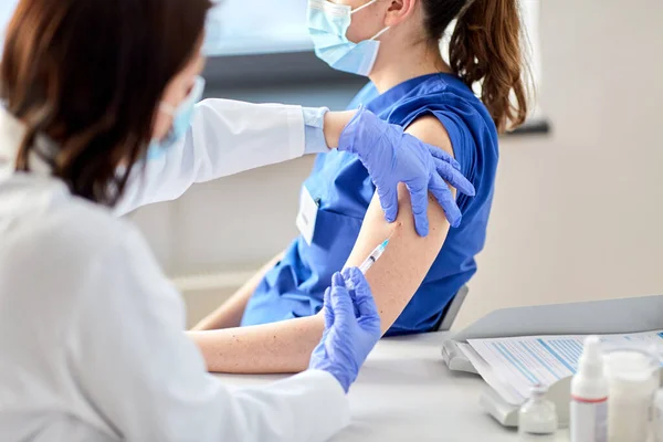 Médico con jeringa vacunando al trabajador médico — Foto de Stock