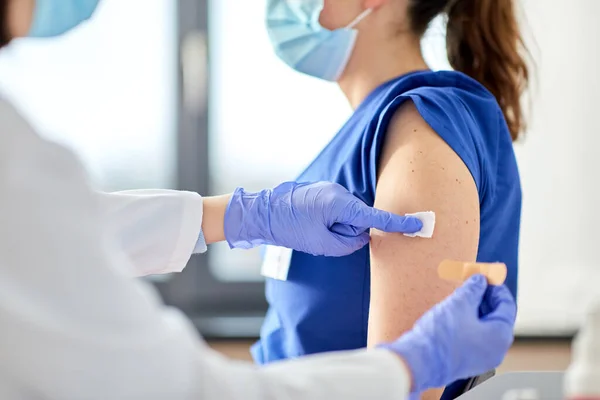 Doctor adjuntando parche al trabajador médico — Foto de Stock