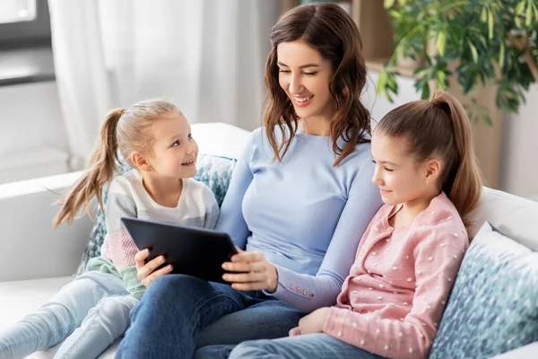 Feliz madre e hijas con la tableta PC en casa —  Fotos de Stock